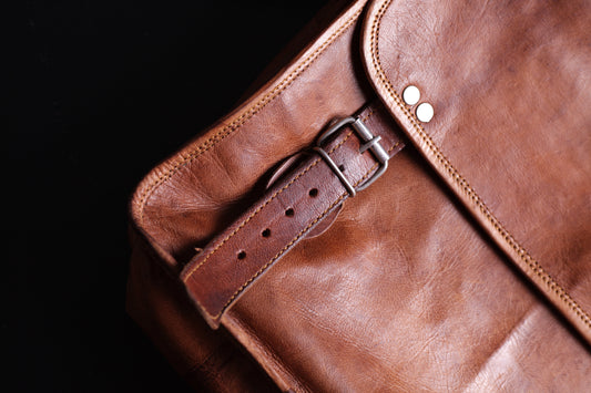 Close-up of brown leather bag showing fine stitching and polished finish.