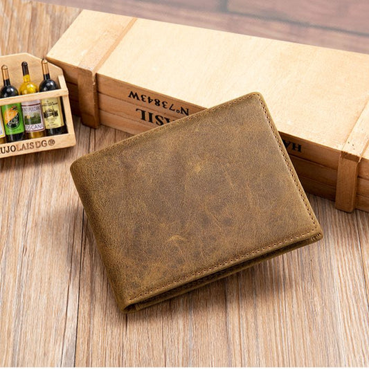 Vintage leather wallet on a wooden surface with a wooden box in the background