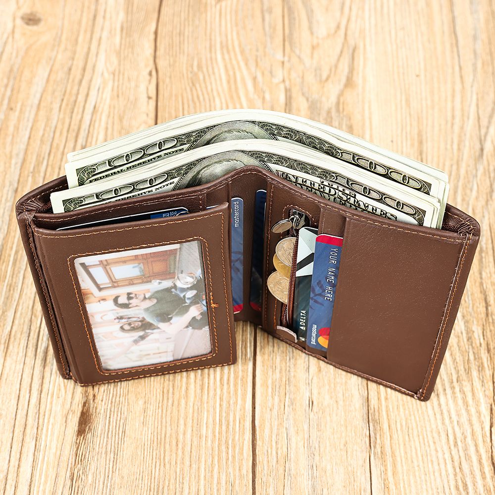 Brown wallet with money, cards, and a photo on a wooden surface